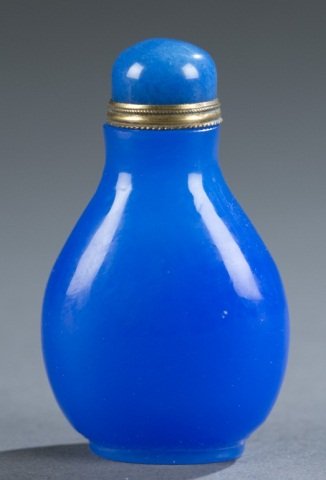 Chinese Peking glass snuff bottle.: A Chinese Peking glass snuff bottle. Semi-transparent light cobalt blue Peking glass. Flattened pear form, on oval foot rim, with metal mounted glass stopper. 2 3/4"h.