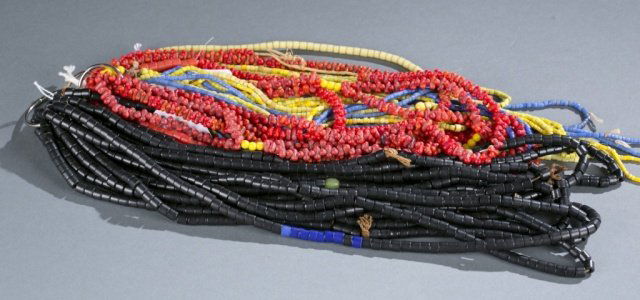 Group of glass trade beads.: A group of glass trade beads. ++ Yellow and blue seed trade beads. 16 strands of small beads. Approx. 8 1/2" - 16 1/2" long. ++ Black and red bohemian glass trade beads. 6 strands of red mock coral be