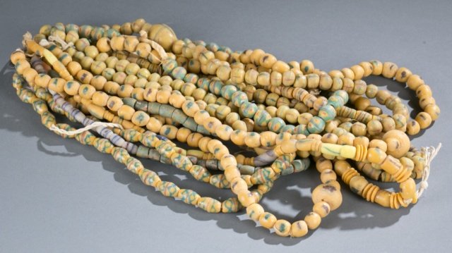 Group of long yellow powder glass trade beads.: A group of longe yellow powder glass trade beads. 10 strands of multicolored round and barrel beads. Approx. 13" - 19" long.Provenance: Patrick J. Lusk Collection. In most cases the date is a 20th cen