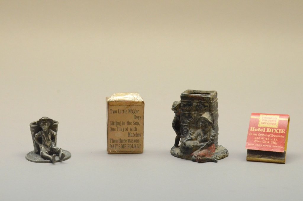 Black Figural Metal Smoking Accessories: [Smoking Accessories] 4 items: 2 matchbook or matchstick holders & 2 sets of matches, all with Black characters. ++ 2 1/2" metal match holder showing 2 Black boys next to a bale marked "Cotton." ++ 1 