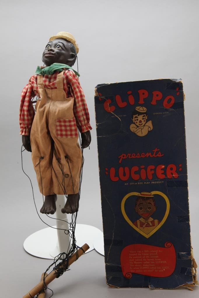 Black Clippo Puppet or Marionette: LUCIFER w/ box.: [Toys/Puppet]. Figure of LUCIFER, a Black puppet or marionette made c. 1930 by Effanbee w/ orig. box. Puppet in good cond. w/ hat, strings and dowel intact, box in poor cond., folded flat. Sold as is.