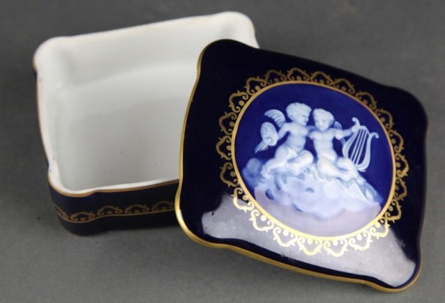 France Limoges Cobalt Porcelain Pate-sur-pate Box.: A France Limoges cobalt porcelain pate-sur-pate box, 20th century. Gilt rim to lid with cupid cameo surrounded by gilt. Marked "France Limoges" on base. 1 1/2" H x 4" W x 3 1/2" D.