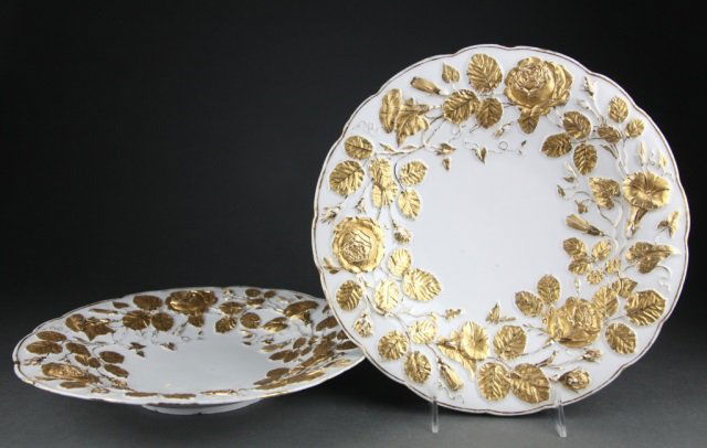 Pair of Meissen Gilt Cabinet Plates.: A pair of Meissen gilt floral relief cabinet plates, late 19th/early 20th century. Crossed swords underglaze mark. 11 1/2" diam. Condition: Chips to foot, and loss to gilt.