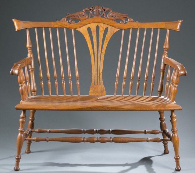 Carved oak settee, Continental, 19th / 20th c.: A carved oak settee. Continental. Late 19th / early 20th century. Having combination turned rail and pierced splat back, two dragons with a shield at crest rail, heavily scrolled handholds, turned leg