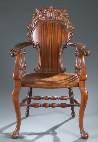 Renaissance revival carved wooden chair.: A Renaissance revival carved wooden armchair. Continental. Mid-19th century. Sold hardwood having heavily carved dragons surrounding a cartouche at top of crest rail, violin back with pierced c-scroll