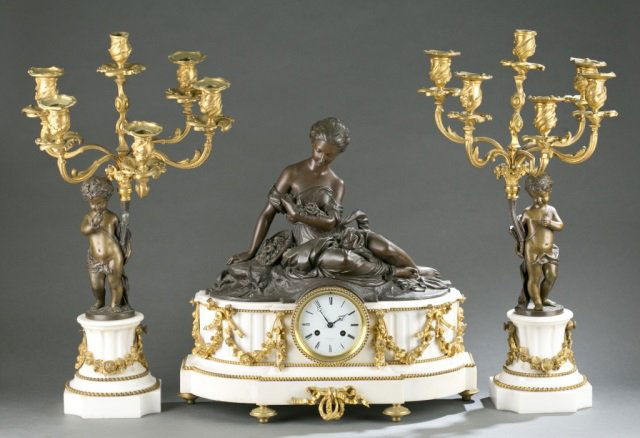 Raingo Freres Louis XVI style garniture set, 19thc: A Raingo Freres Louis XVI figural garniture set. French. 19th century. No. 3157. Mantel clock with seated female figure holding flowers on white marble plinth, ormolu swags, wreaths, and ribbons. Cloc