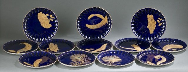 12 special ordered Spode feather plates.: A set of 12 Spode Copeland plates. c.1875-1890. Having a solid cobalt blue ground with ruffled rims edged in gold. Each plate having a unique off-centered pattern of raised and metallic exotic feather