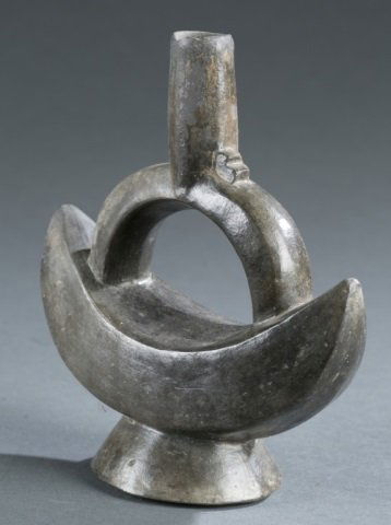 Northern Peru Pre-Columbian style stirrup vessel.: A Chimu style ceramic stirrup vessel in the shape of a crescent. North Coast Peru. c.20th century. 7 1/4"h x 6 1/4"w x 3"d. Please note that unless stated stands do not come with pieces.