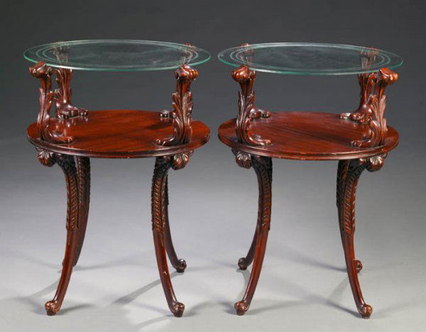 Pair of mahogany side tables: Pair of mahogany side tables. Having four leaf carved supports supporting a glass top, over a mahogany top supported on acanthus-leaf carved legs. c.1940. 28"h x 20"diam. This is a live auction at our