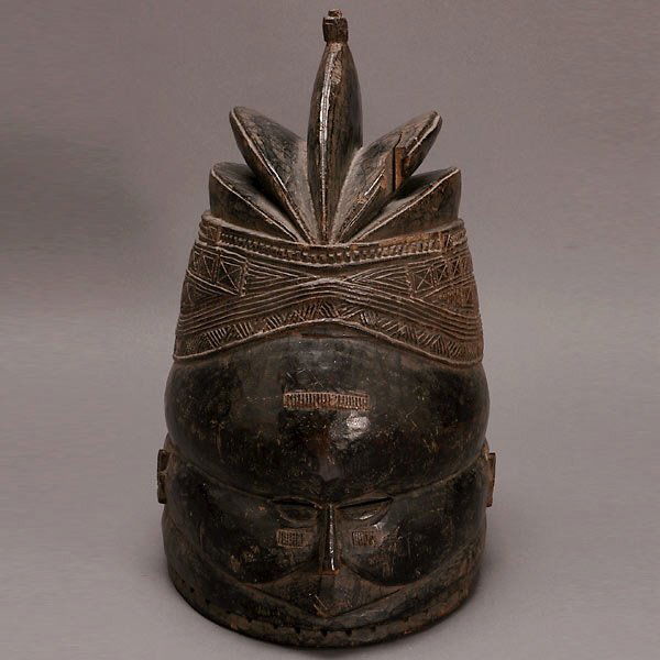 MENDE BUNDU SOWEI HELMET MASK AFRICAN ART: MENDE BUNDU HELMET MASK. Blackened wood with small facial features, slit eyeholes, scarification band on forehead, five-lobed crested coiffure with finely incised geometric patterning. Sierra Leone. M