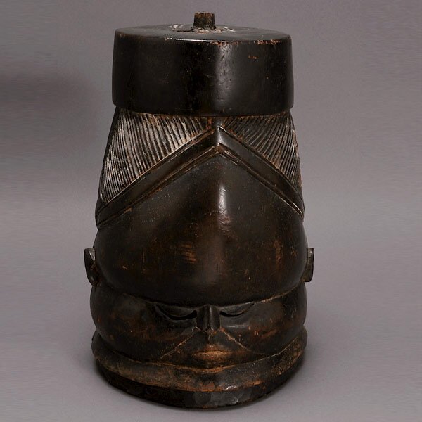 MENDE BUNDU SOWEI HELMET MASK AFRICAN ART: MENDE BUNDU HELMET MASK. Wearing a pillbox type hat, grooved coiffure, downcast eyes with slit eyeholes. Blackened wood with traces of white pigment in the grooves. Sierra Leone. Mid-20th century. 12