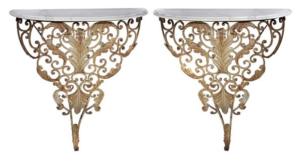 A pair of French wrought iron and calacatta vagli: A pair of French wrought iron and calacatta vagli marble mounted console tables, early 20th century, with variegated white marble demi-lune tops, on openwork scroll formed and foliate pressed