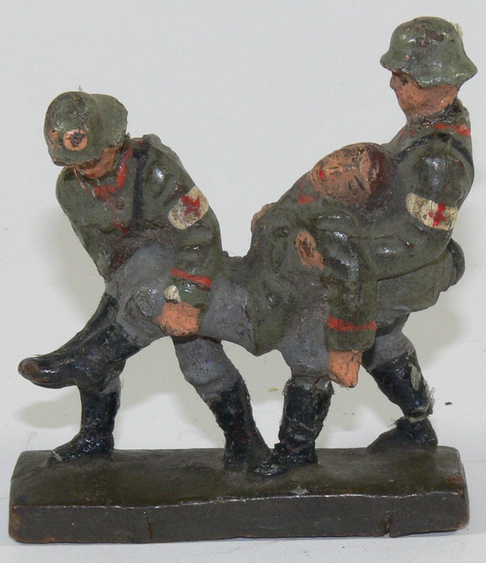 Lineol zwei SanitÃ¤ter einen Verwundeten tragend. Masse: Lineol zwei SanitÃ¤ter einen Verwundeten tragend. Masse handbemalt. 7 cm - Serie. Gemarkt. Altersbedingter Farbabrieb.