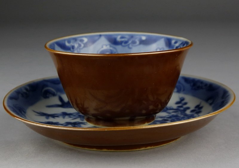 A SET OF BROWN GLAZED BLUE & WHITE TEA CUP AND SAUCER: Kangxi period, brown glazed blued and white cup with saucer painted two birds and pine tree, bamboo and flower. 康熙期酱釉加青花茶杯、