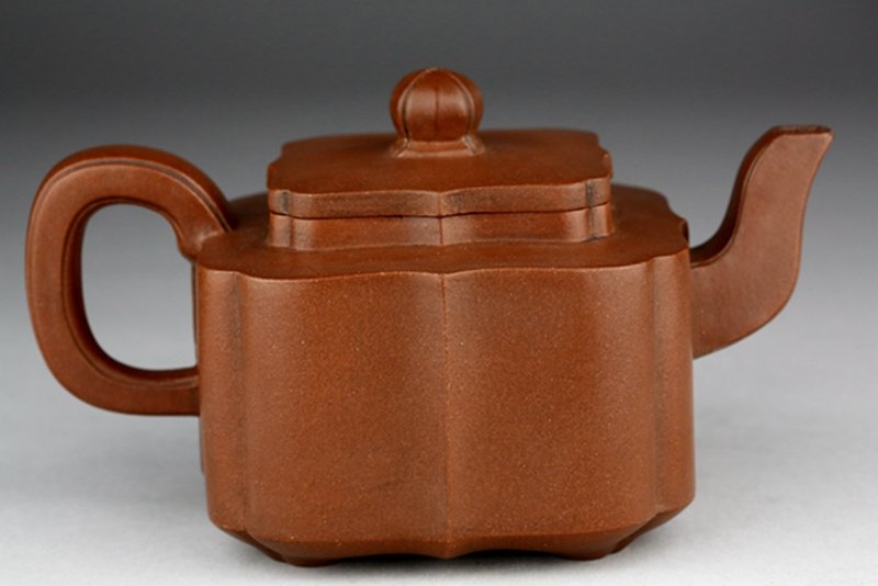 A YIXING SQUARE TEAPOT AND COVER: Wu Yun Gen mark. Zhuni square teapot and cover. 吴云根款朱泥四方葵边壶 W: 16.8cm; H: 9.6cm.