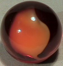 BB Marbles: Peltier Root Beer Float: PELTIER GLASS COMPANY, Root Beer Float. Transparent brown marble with wide opaque white ribbon in it. Small melt dimple on one side. From the limited run of Nova types by Peltier. 31/32". Mint (9.9).