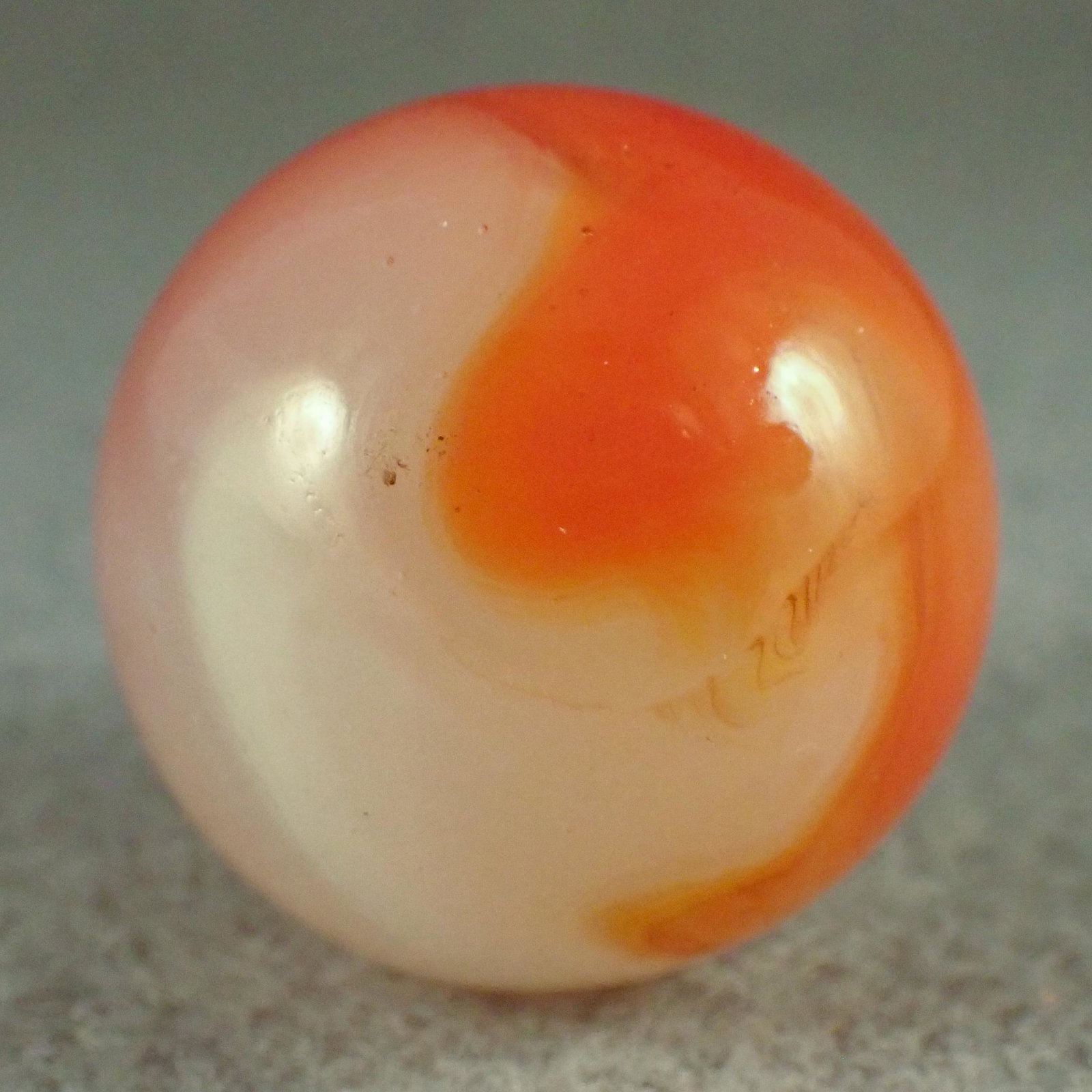 MARBLES. AKRO AGATE COMPANY, Corkscrew. 31/32". Near: AKRO AGATE COMPANY, Corkscrew. "Tomato Soup" Corkscrew. Translucent white base with opaque wispy white corkscrew and semi-opaque light orangish red corkscrew. One tiny subsurface moon, a couple of tin
