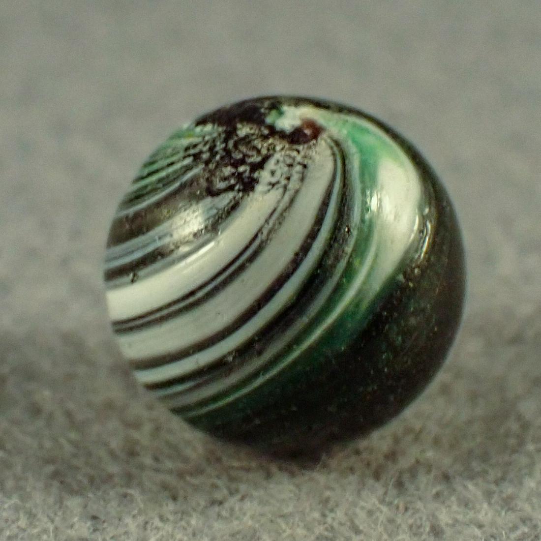 MARBLES. OTHER HANDMADE, Indian. 15/32". Mint (9.9).: OTHER HANDMADE, Indian. Opaque black base. About seventy percent covered with stretched green and white bands. In great shape. Hard to find Peewee. Germany, circa 1860-1920. 15/32". Mint (9.9).