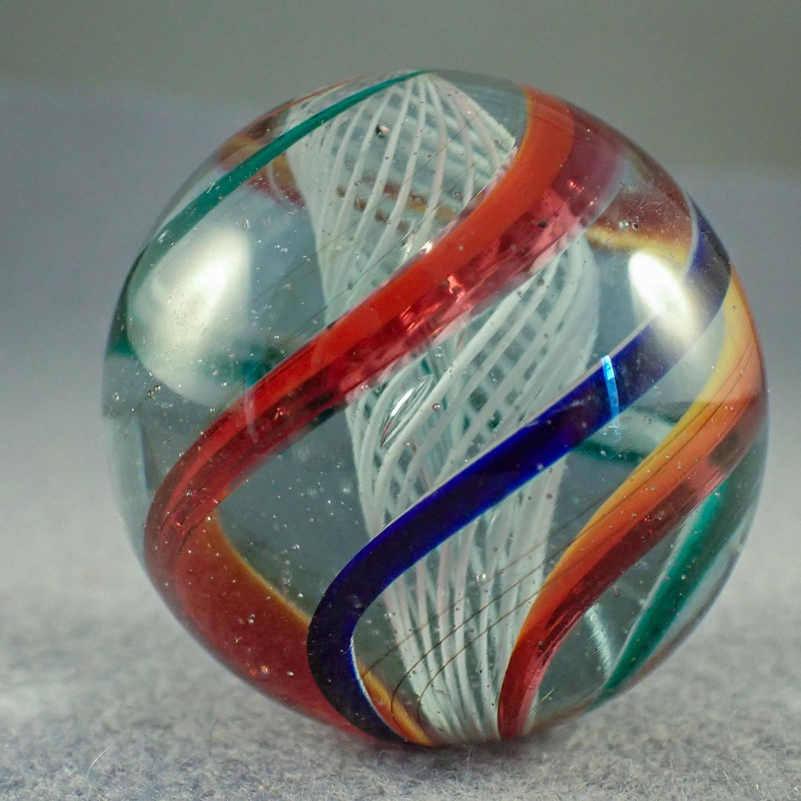 Marbles. SWIRL, Latticinio Core. 1-5/8". Polished: SWIRL, Latticinio Core. White Latticinio Core. Outer layer is four bands. Polished surface, no remnants of damage remain. Germany, circa 1860-1920. 1-5/8". Polished.