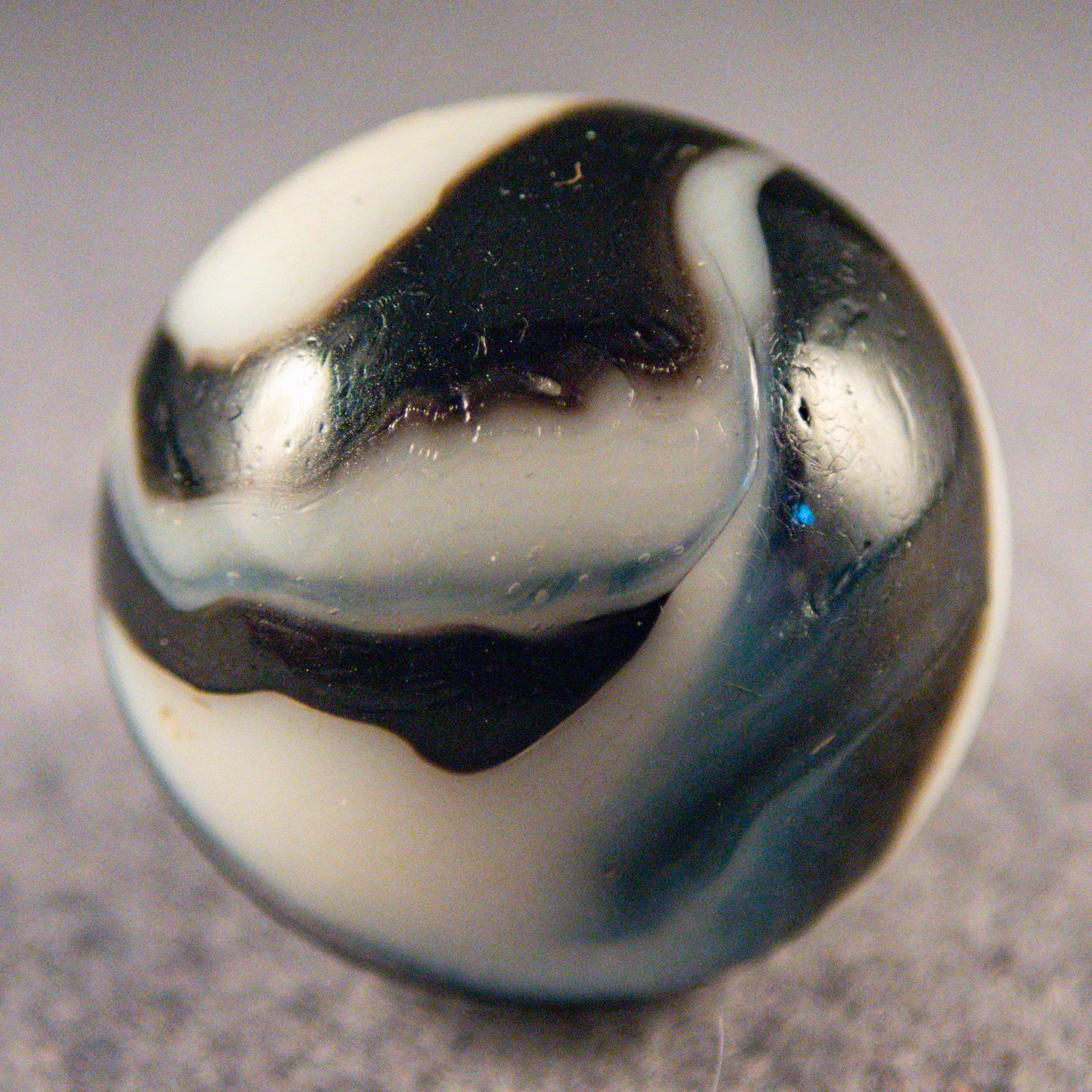 Marbles. PELTIER GLASS COMPANY, National Line Rainbo Zebra. 7/8". Mint (9.9).: PELTIER GLASS COMPANY, National Line Rainbo. Four-ribbon two-color National Line Rainbo Zebra. Four black ribbons in white base. Aventurine in the black. Shooter. Ottawa IL, circa 1925-1935. 7/8". Min