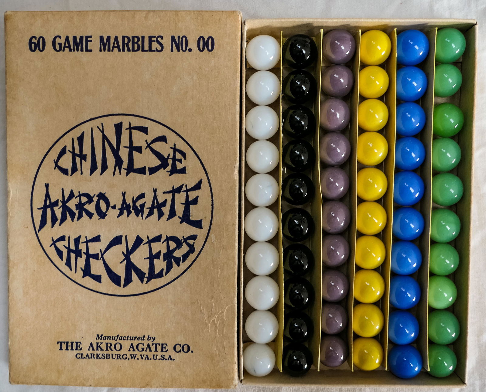 Marbles: AKRO AGATE COMPANY, Original Package. Chinese Checker Box.: Marbles: AKRO AGATE COMPANY, Original Package. Chinese Checkers box. A white cover one. 60 Game Marbles No. 00. Clarksburg WV, circa 1930-1940. 6-1/8" x 3-3/4" x 5/8". Mint.