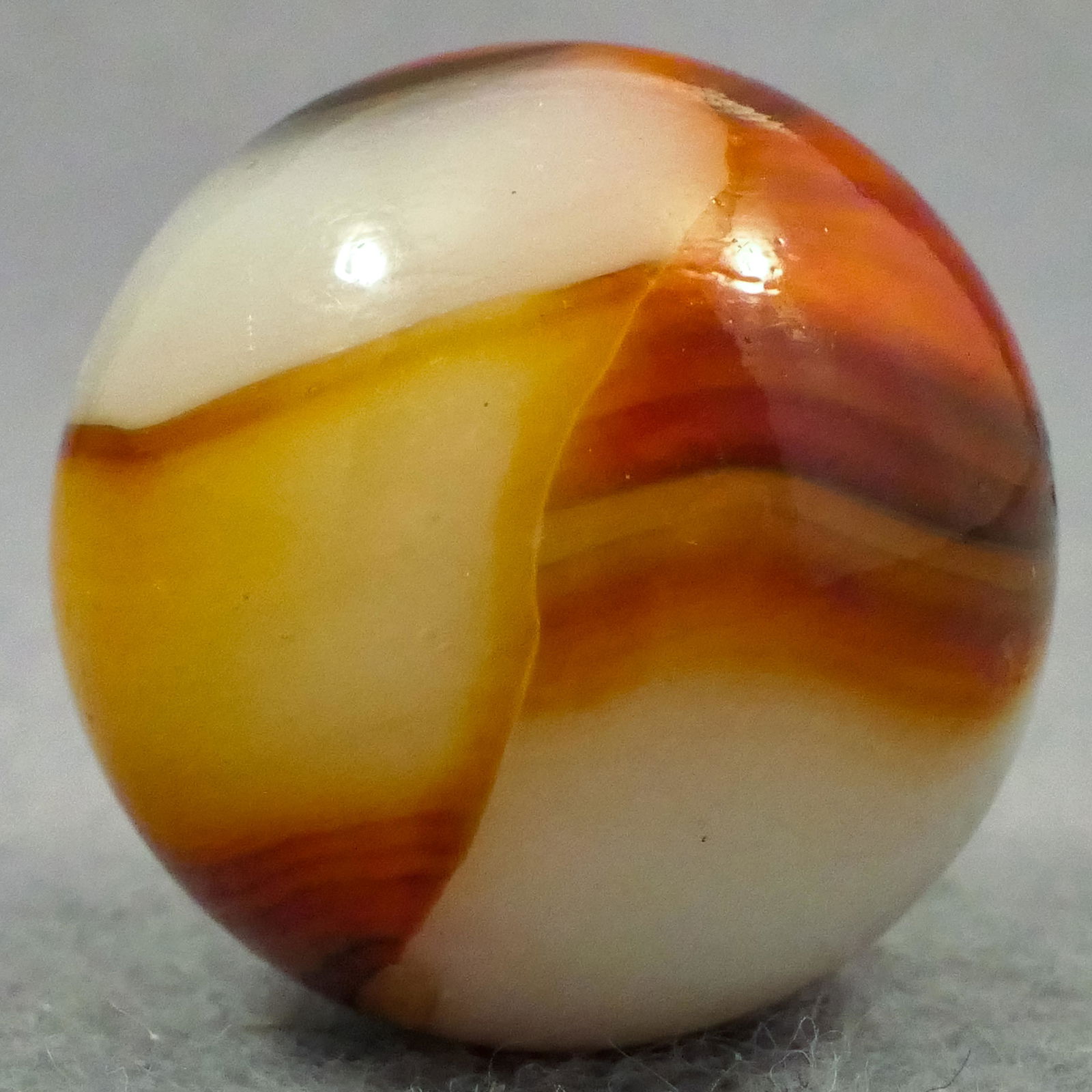 Marbles: PELTIER GLASS COMPANY, Rainbo. 31/32". Mint (9.9).: Marbles: PELTIER GLASS COMPANY, Rainbo. Shooter. White base. Two very wide ribbons of red with brown streaks. Ottawa IL, circa 1930-1940. 31/32". Mint (9.9).