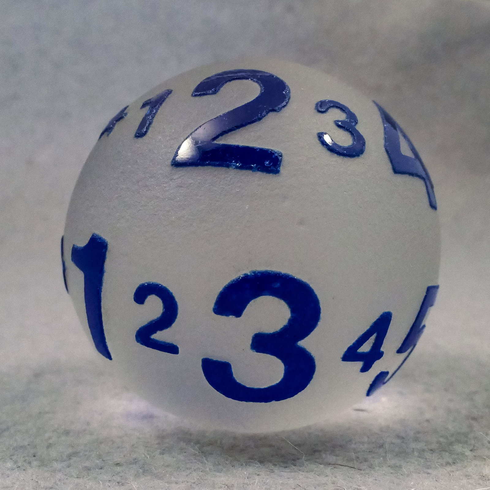 Marbles: CONTEMPORARY HANDMADE, Harry Bessett. 1-9/16". Mint (9.9).: CONTEMPORARY HANDMADE, Harry Bessett. Cameomarble. Clear base with blue overlay. Cut away to leave a blue series of numbers. 1 through 0 spiraling twice around the marble. Unsigned, but it is by Harry