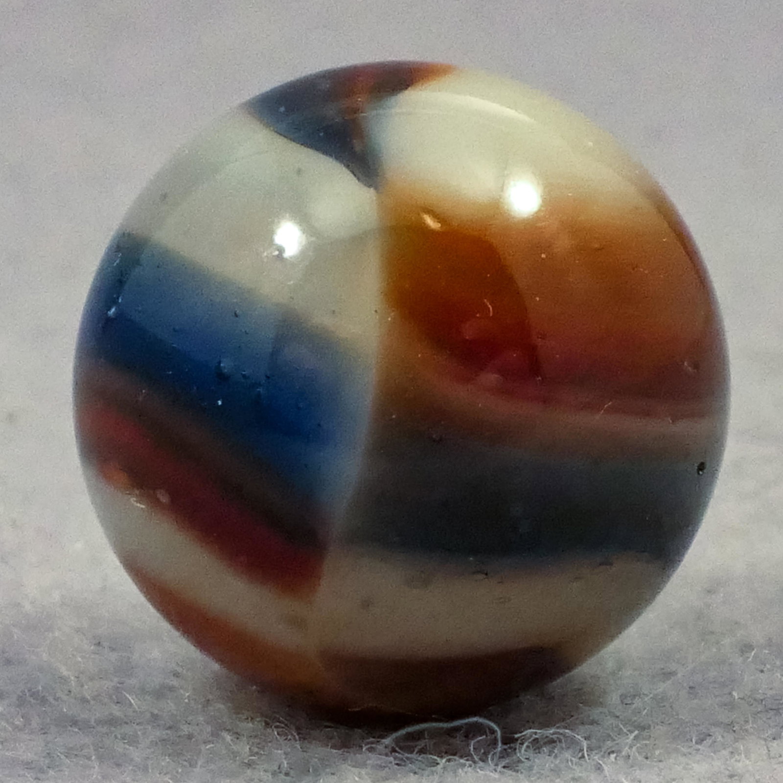 Marbles: PELTIER GLASS COMPANY, National Line Rainbo Liberty. 19/32". Mint (9.9).: PELTIER GLASS COMPANY, National Line Rainbo. Eight-ribbon three-color National Line Rainbo Liberty. Precision ribbons. Five brownish red ribbons, three blue ribbons. Ottawa IL, circa 1925-1935.19/32".