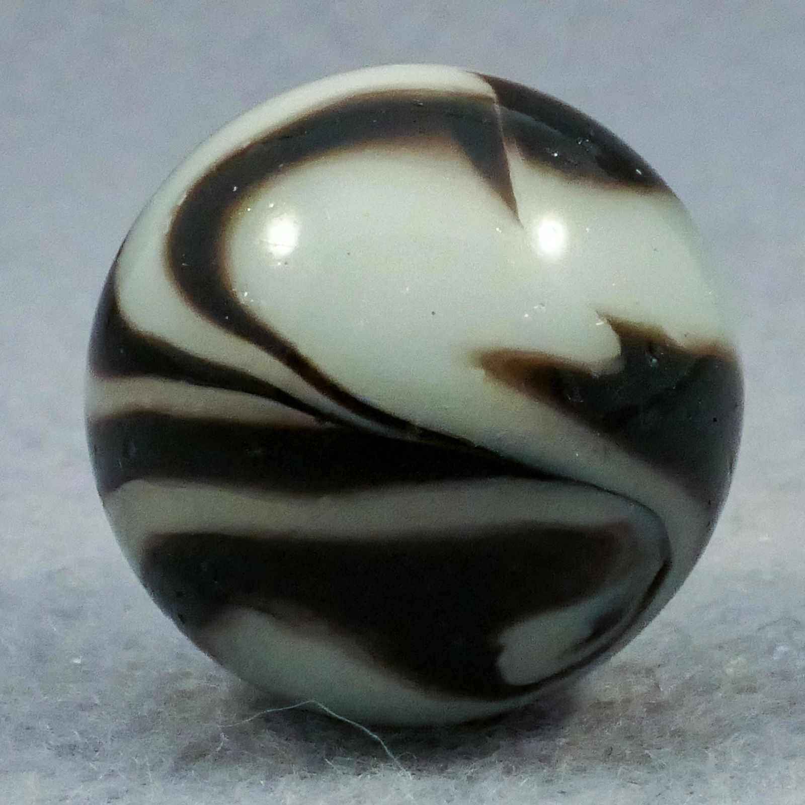 Marbles: PELTIER GLASS COMPANY, National Line Rainbo. Zebra. 11/16". Near Mint(+) (8.9).: PELTIER GLASS COMPANY, National Line Rainbo. Four-ribbon two-color National Line Rainbo Zebra. Four black ribbons on white. Some pits and pinpricks. Ottawa IL, circa 1925-1935. Provenance: ex-collecti