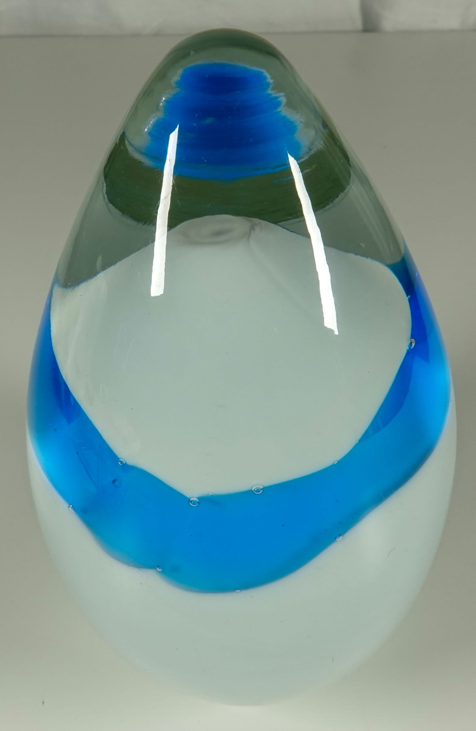 PAPERWEIGHT, Murano. Mexico.: PAPERWEIGHT, Murano. Conical style. Lower half is white. Two rings of transparent blue. Paper label on it reading "crisales de Murano Hecho en Mexico). Width: 3-1/2". Height: 4-1/2". Mint.