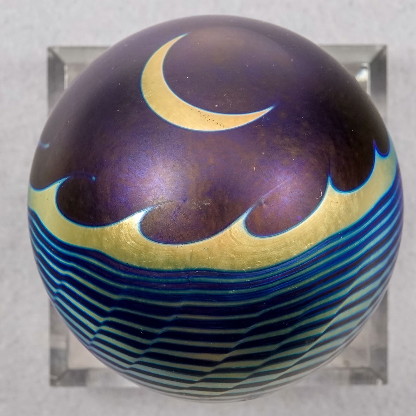 PAPERWEIGHT, Correia Art Glass. Solar Eclipse.: PAPERWEIGHT, Correia Art Glass. Solar Eclipse. The Sun being eclipsed by the moon, with ocean waves around the base. Very nice. Signed "Correia MSCIM - 105.83.4" and has a paper label. 2-3/8" width, 2