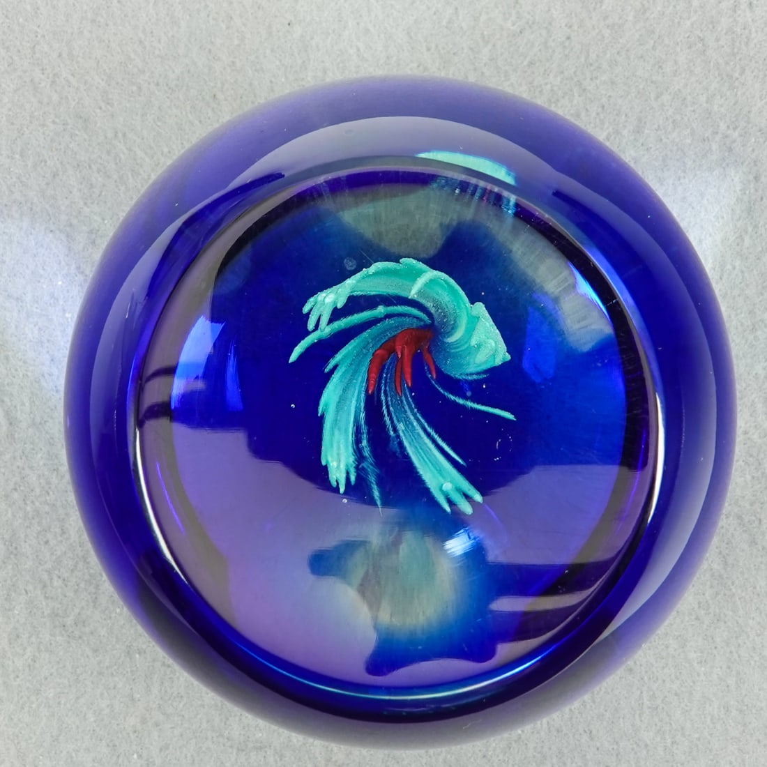 PAPERWEIGHT, Caithness Glass. Lunar Orchid.: PAPERWEIGHT, Caithness Glass. Large viewing window. Flat base. Signed on base "Lunar Orchid Caithness Scotland 400/750" Limited edition. 3-1/4" width, 2-7/8" height. Mint.