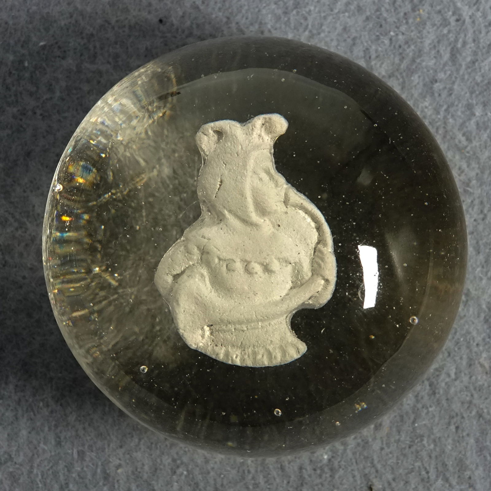 PAPERWEIGHT, Lauscha. Sulphide.: PAPERWEIGHT, Lauscha. Sulphide figure in clear glass. Figure is a jester blowing a horn. Plaque type. Well centered. No air bubbles. Good silvering. Germany, circa 1860-1900. 1-3/4" width, 1-1/4" heig