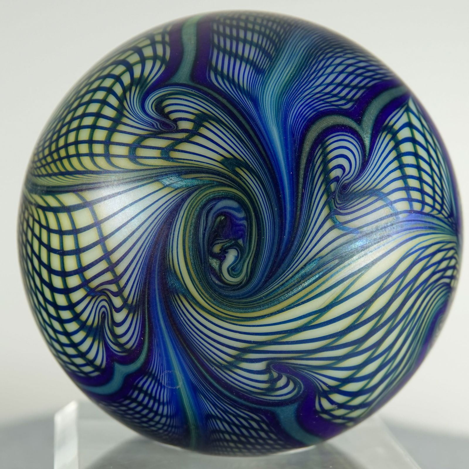 PAPERWEIGHT, Correia Art Glass.: PAPERWEIGHT, Correia Art Glass. Opaque white base with blue and green surface pattern. Signed on the bottom "Roland R Correia 12-75 1856". 3" width, 2-3/8" height. Mint.
