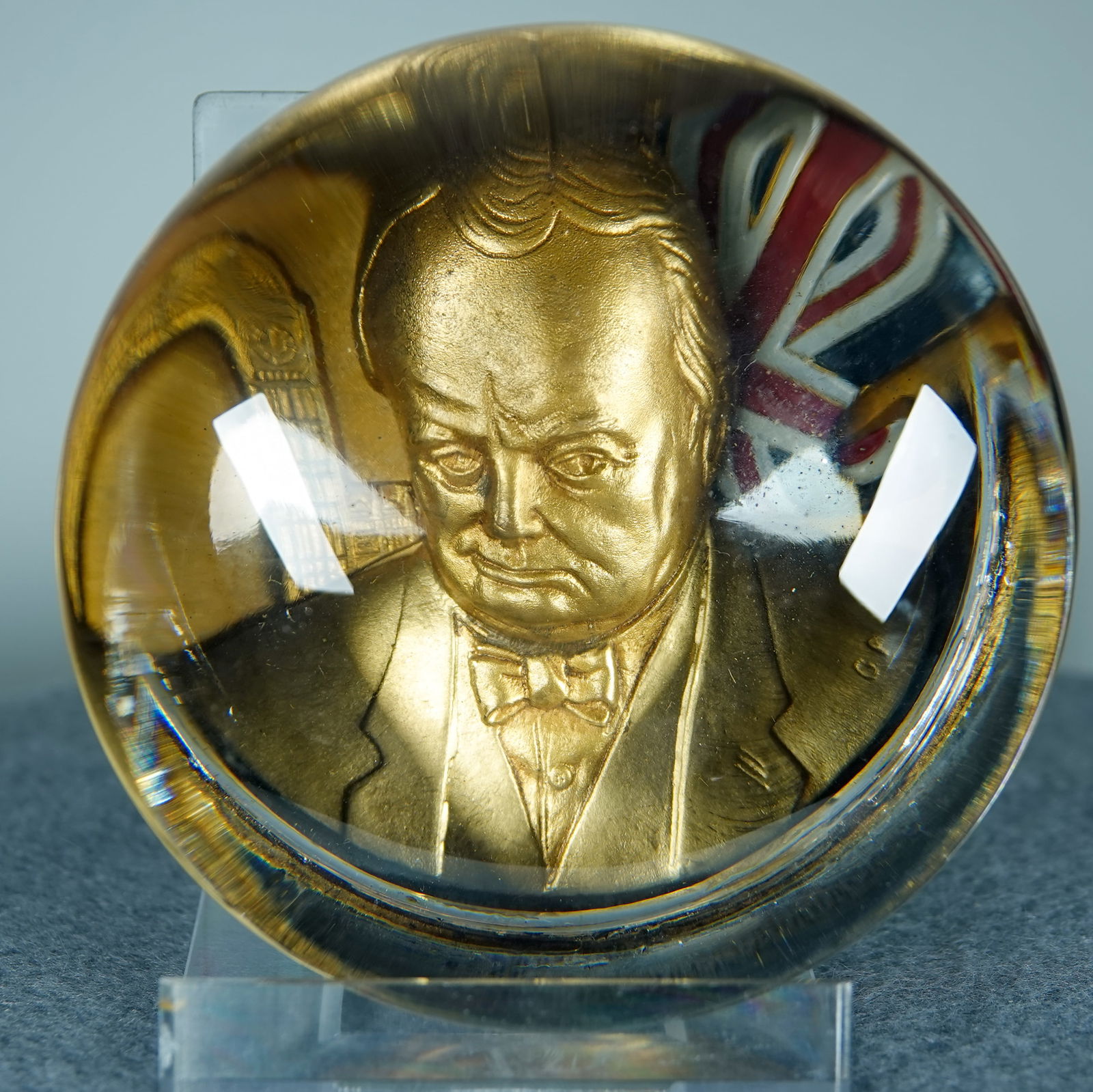 PAPERWEIGHT, St. Louis. Pinchbeck. Winston Churchill. Limited Edition.: PAPERWEIGHT, St. Louis. A limited edition pinchbeck paperweight of Winston Churchill. Cast bronze disk with relief bust of Winston Church, Big Ben behind on shoulder and an enamel Union Jack behind th