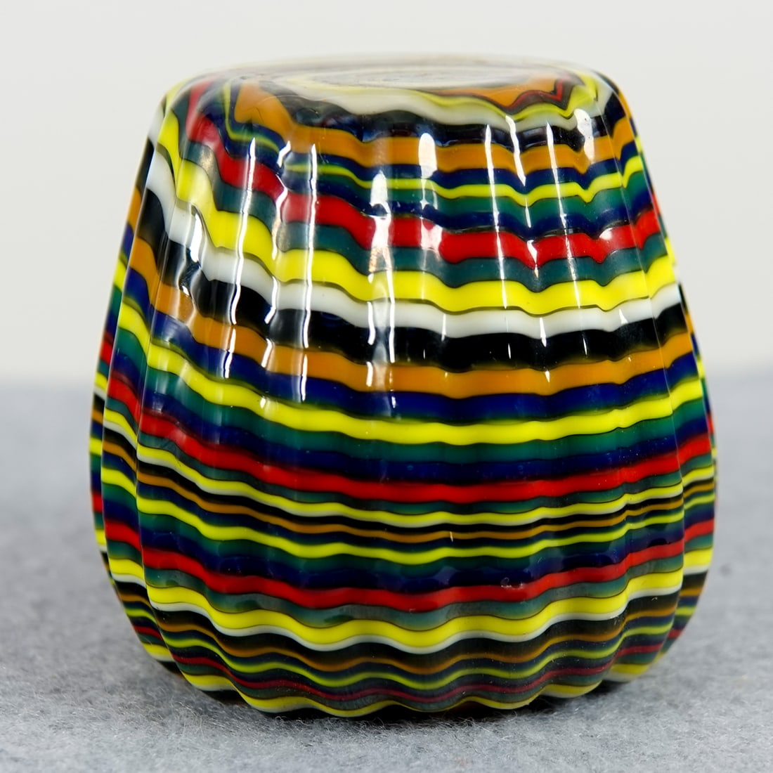 PAPERWEIGHT, Davis Art Glass.: PAPERWEIGHT, Davis Art Glass. Tapered, reeded cylinder in a snakeskin pattern. Flat top and bottom. Signed on bottom "Davis Glass 11". 1-3/4" width, 1-3/4" height. Mint.