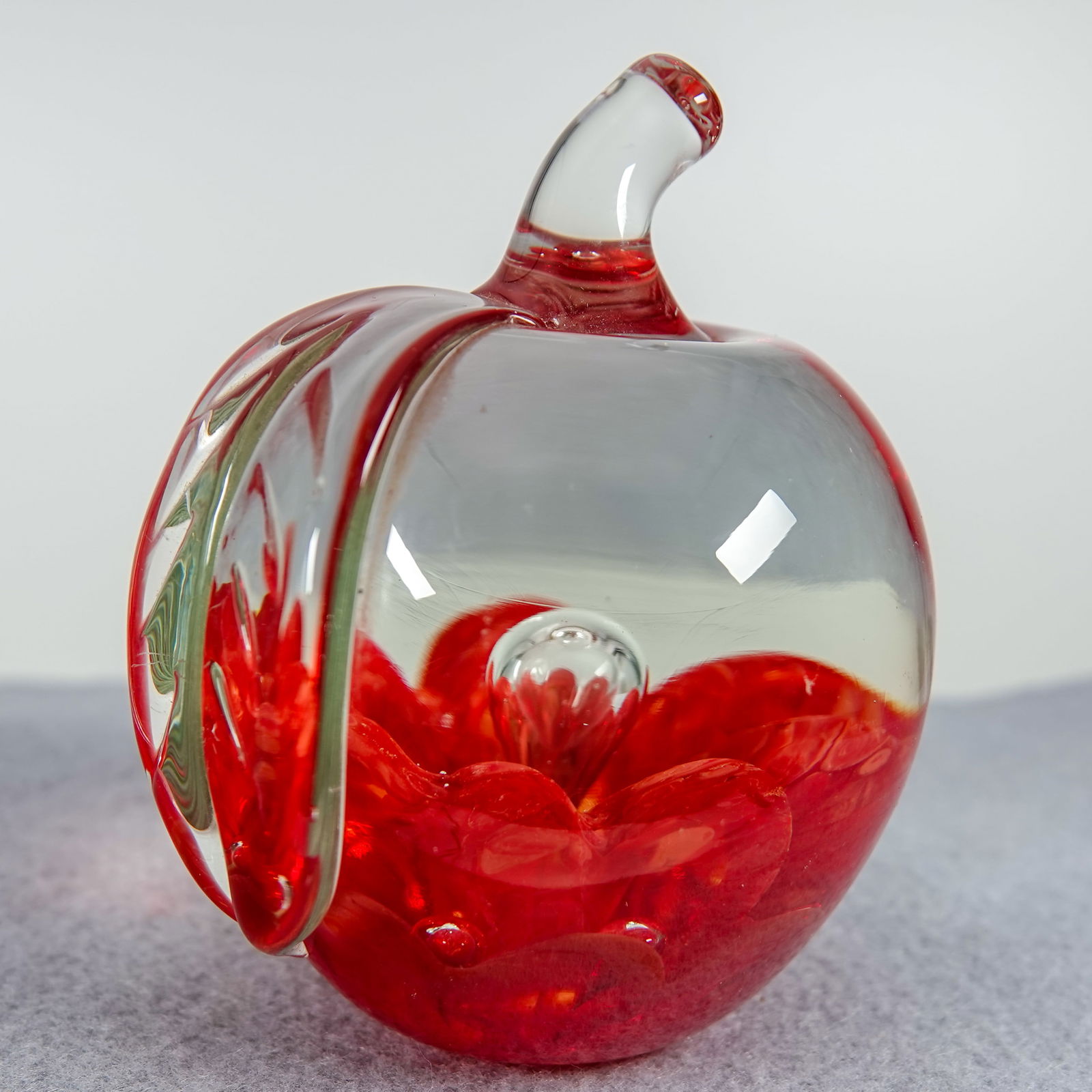 PAPERWEIGHT, Joe St. Clair. Apple.: PAPERWEIGHT, Joe St. Clair. Glass apple with red base. Embossed on bottom "Joe St. Clair". 2-7/8" width, 2-3/4" height.