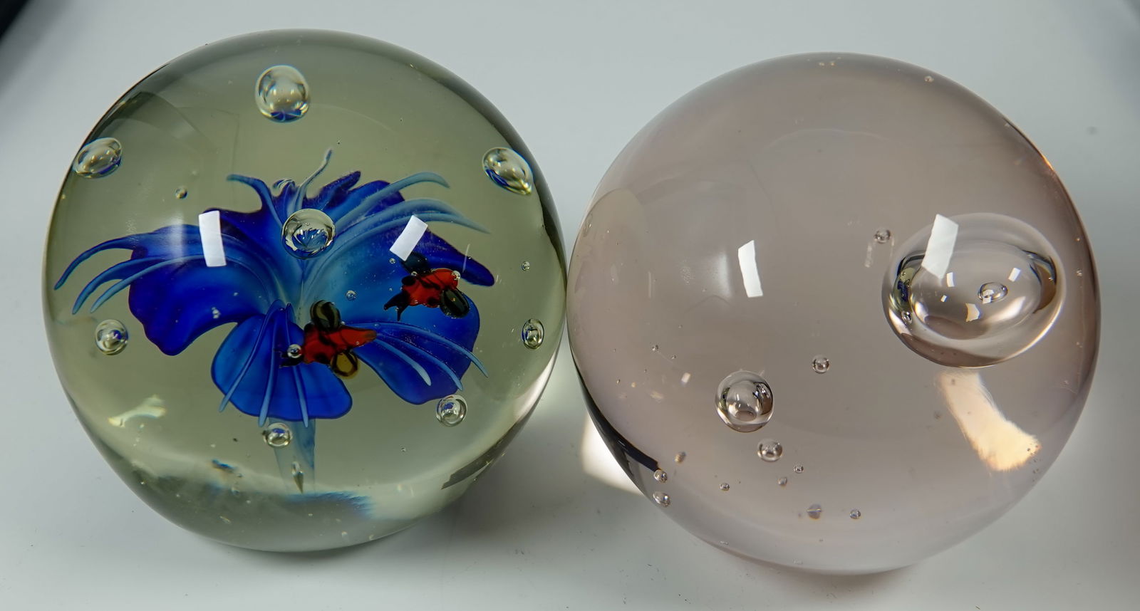 PAPERWEIGHT. 2 paperweights.: PAPERWEIGHT. Lot of two items. Both are Paperweights. One is a Chinese flower weight. Has a paper label on the bottom "Silvestri". 3-3/8" width, 3-1/4" height. Mint. Other is a clear weight with air b