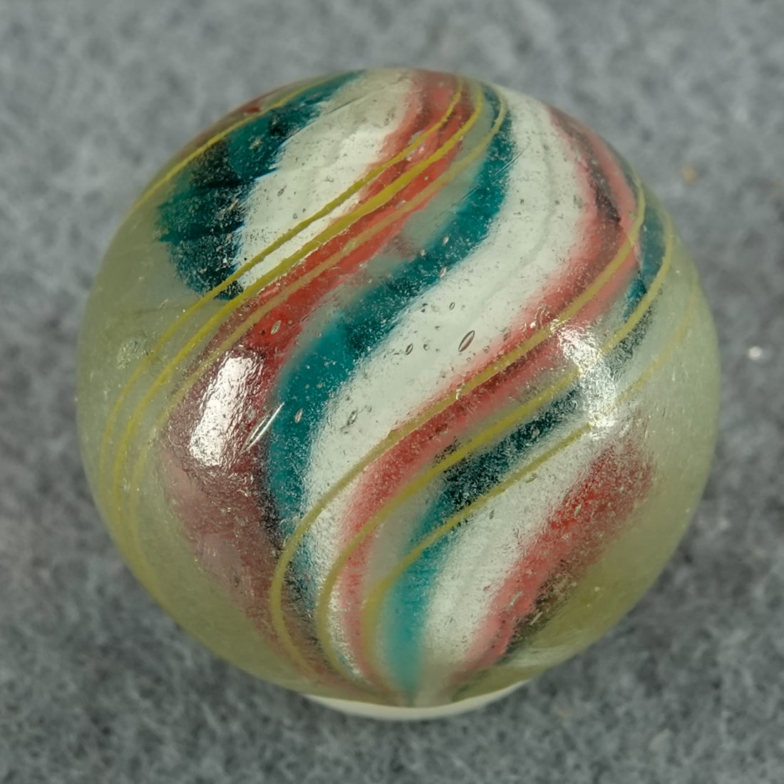 SWIRL, Solid Core. 25/32". Near Mint(+) (8.9).: SWIRL, Solid Core. Solid Core Swirl from near an end of the cane. Nice looping strand in the outer layer. Overall pocket wear. Germany, circa 1860-1920. 25/32". Near Mint(+) (8.9).