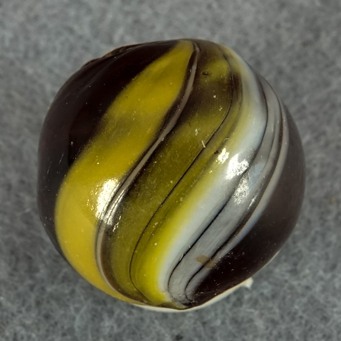 OTHER HANDMADE, Indian. Transparent. 11/16". Near Mint(+) (8.9).: OTHER HANDMADE, Indian. Transparent Indian. Transparent light currant red base. Two wide bands of stretched color. Two tiny subsurface moons. Germany, circa 1860-1920. 11/16". Near Mint(+) (8.9).