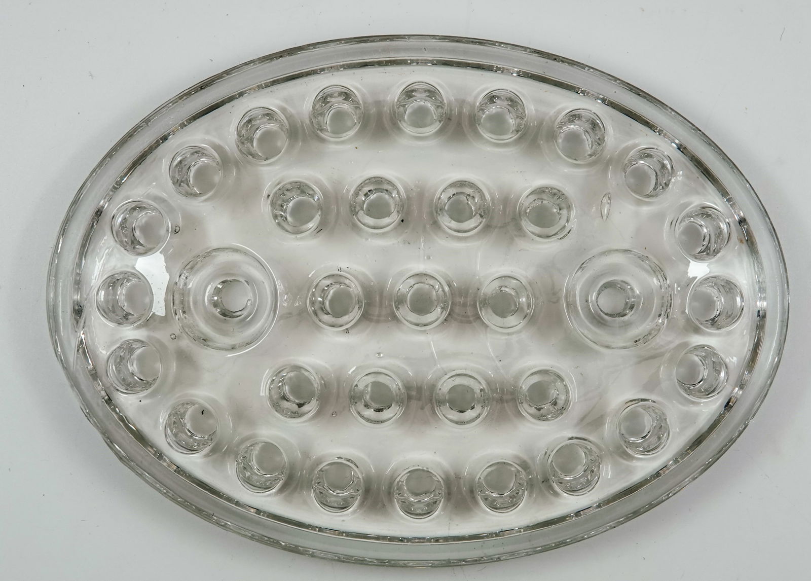 MISCELLANEOUS, Display Item. Glass flower frog.: MISCELLANEOUS, Display Box. Glass flower frog for use as a marble display. Antique. Flat oval frog. Usually these are domed and the marbles roll off, but this one is almost flat. Great display piece.