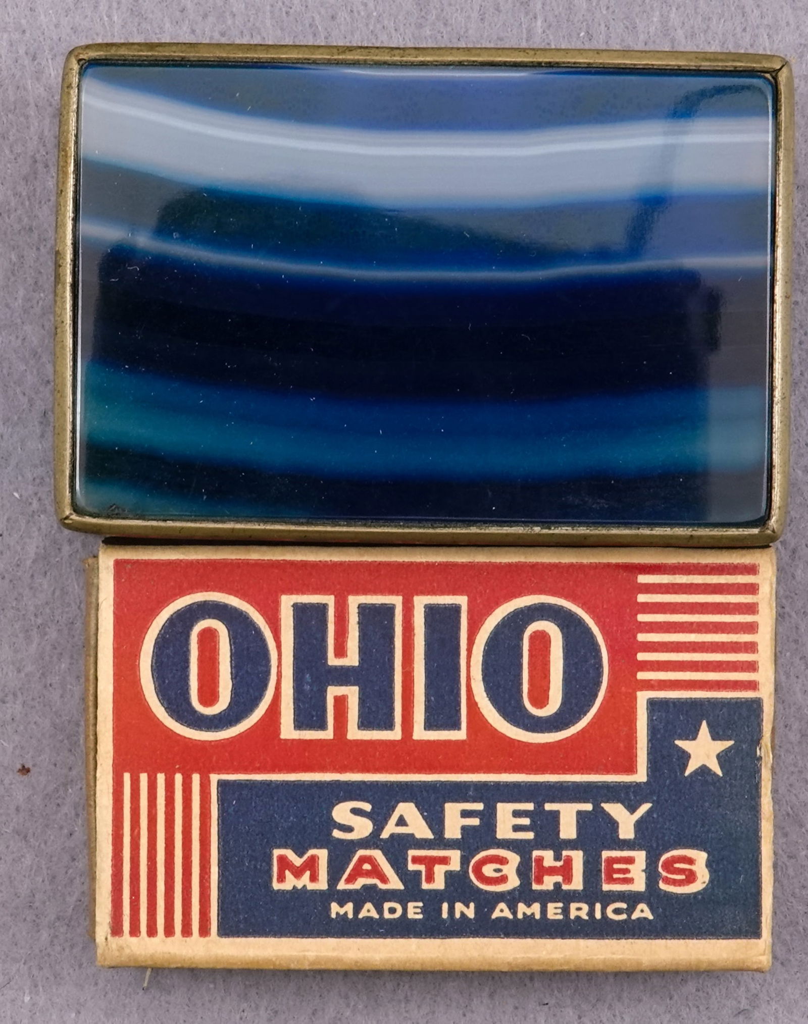 MISCELLANEOUS, Objet d'vertu. Antique agate matchbox holder.: MISCELLANEOUS, Objet d'vertu. Antique agate matchbox holder. Very unusual agate item. A matchbox holder with a piece of polished beveled blue dyed agate on either side of the white metal frame. Design