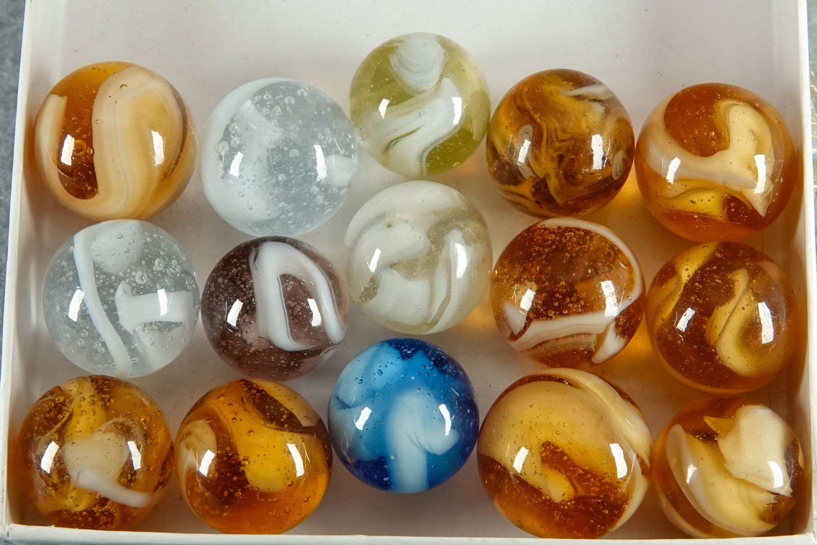 CHRISTENSEN AGATE COMPANY, Swirl. 15 marbles.: CHRISTENSEN AGATE COMPANY, Swirl. Lot of fifteen marbles. All are opaque white in a transparent clear or transparent color base. Cambridge OH, circa 1925-1930. 19/32" to 21/32". Mint to Mint(-).