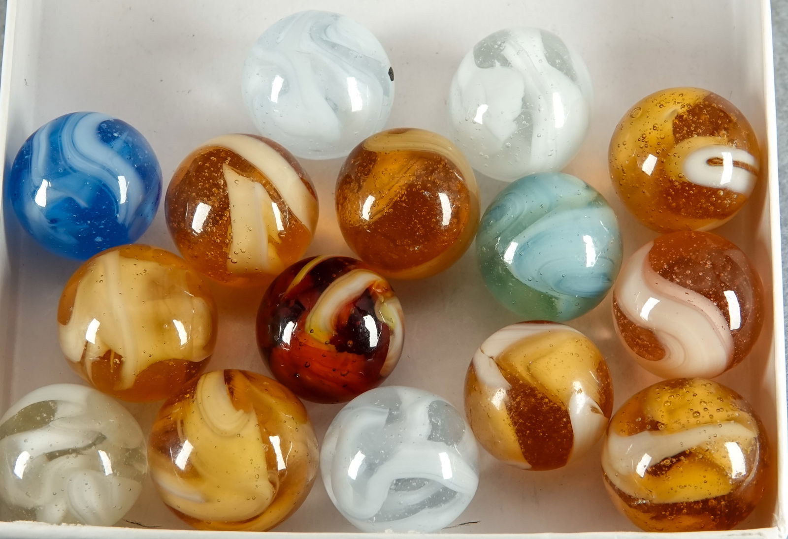 CHRISTENSEN AGATE COMPANY, Swirl. 15 marbles.: CHRISTENSEN AGATE COMPANY, Swirl. Lot of fifteen marbles. All are opaque white in a transparent clear or transparent color base. Cambridge OH, circa 1925-1930. 19/32" to 21/32". Mint to Mint(-).