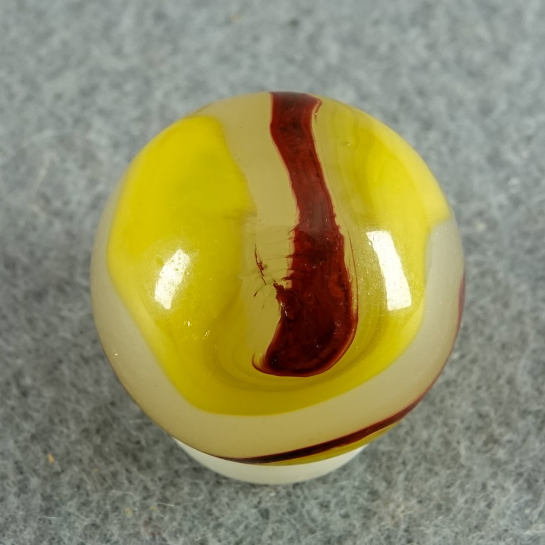 AKRO AGATE COMPANY, Egg Yolk Oxblood. 23/32". Near Mint(+) (8.9).: AKRO AGATE COMPANY, Egg Yolk Oxblood. Milky white base with opaque yellow and rich oxblood. One tiny chip. Clarksburg WV, circa 1925-1935. 23/32". Near Mint(+) (8.9).