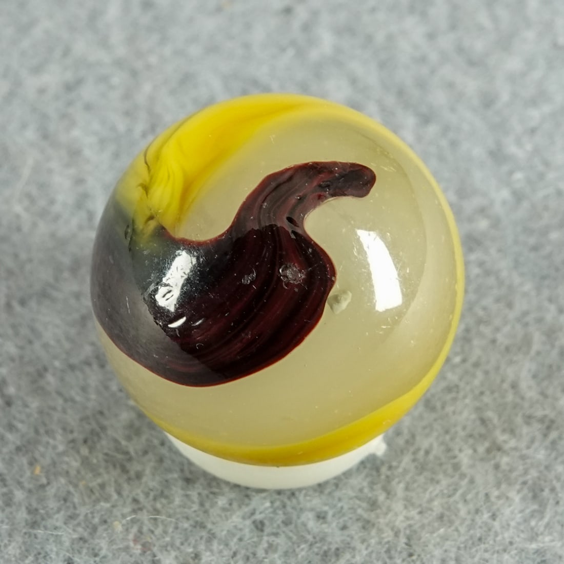 AKRO AGATE COMPANY, Egg Yolk Oxblood. 11/16". Near Mint(+) (8.9).: AKRO AGATE COMPANY, Egg Yolk Oxblood. Milky white base with opaque yellow and rich oxblood. One very tiny chip. Clarksburg WV, circa 1925-1935. 11/16". Near Mint(+) (8.9).