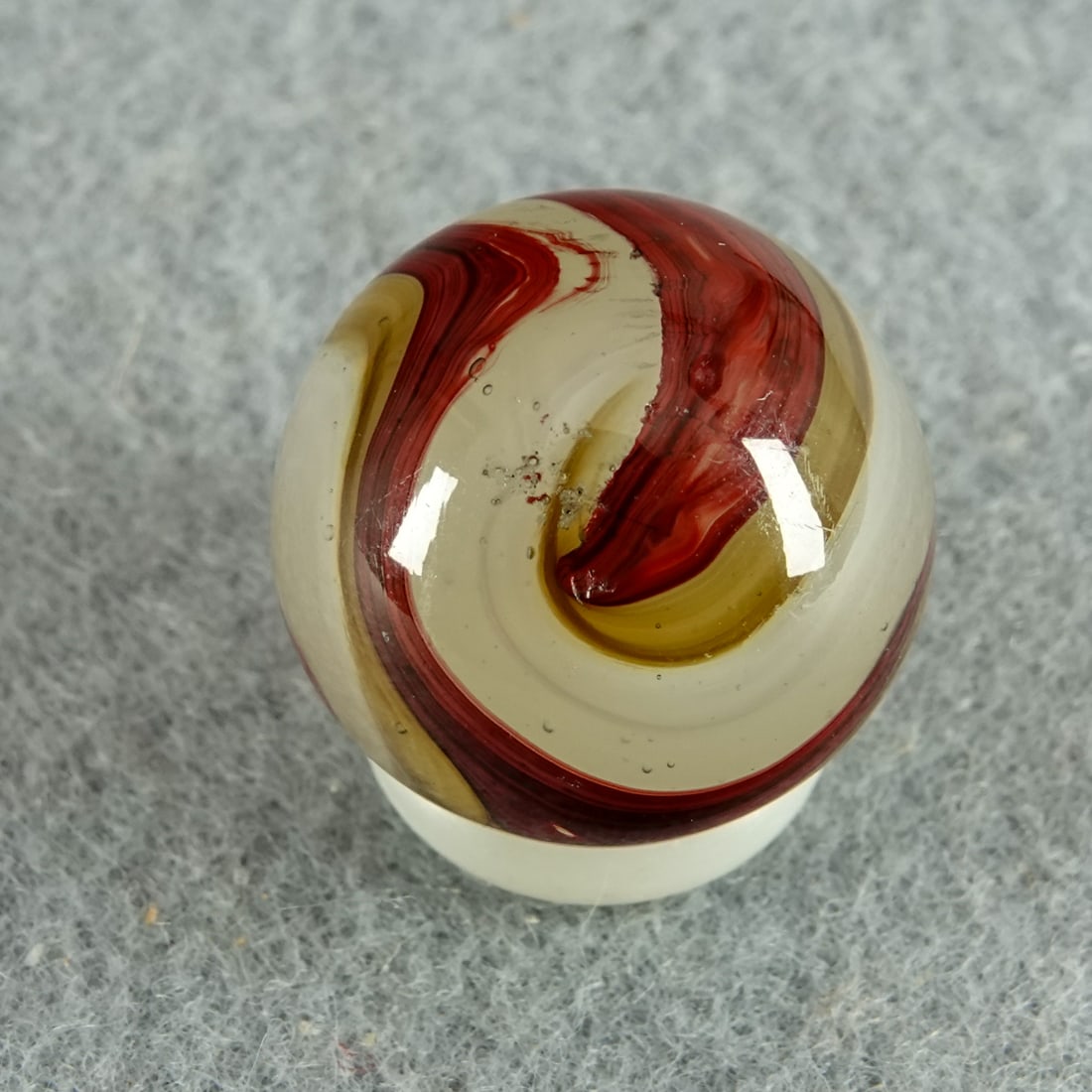 AKRO AGATE COMPANY, Carnelian Oxblood. 21/32". Mint (9.9).: AKRO AGATE COMPANY, Carnelian Oxblood. Milky white base. Surface swirls of semi-opaque white, translucent brown and oxblood. Not fluorescent. Looks like a Silver Oxblood with brown swirls. Clarksburg