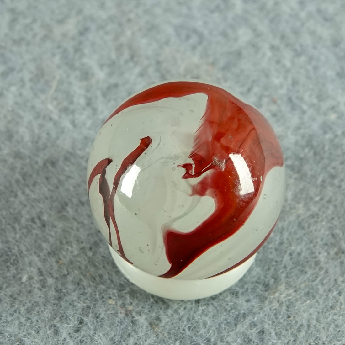AKRO AGATE COMPANY, Silver Oxblood. 5/8". Mint (9.9).: AKRO AGATE COMPANY, Silver Oxblood. Translucent white base with milky white swirls and nice oxblood on the surface. Clarksburg WV, circa 1925-1935. 5/8". Mint (9.9).