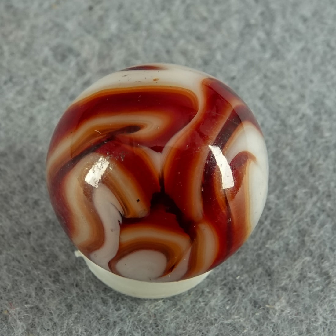 ALLEY AGATE COMPANY, Swirl. 23/32". Mint (9.9).: ALLEY AGATE COMPANY, Swirl. Transparent red swirls in white. West Virginia, circa 1930-1940. 23/32". Mint (9.9).