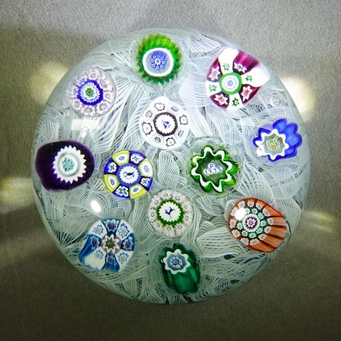 PAPERWEIGHT, Perthshire Paperweights.: PAPERWEIGHT, Perthshire Paperweights. Scramble paperweight with date cane and silhouette canes. Date cane is "P 1975". Silhouettes include Puffin, Sailboat and Stag. 2-3/4" wide, 1-7/8" high .